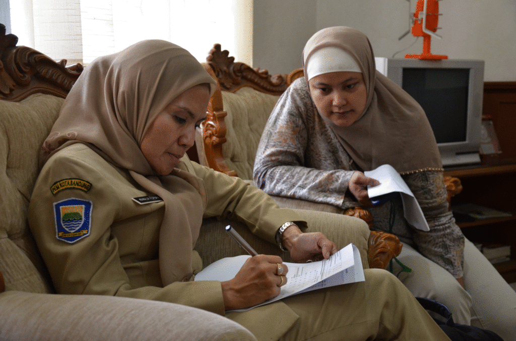 Two women sitting on a couch filling out forms