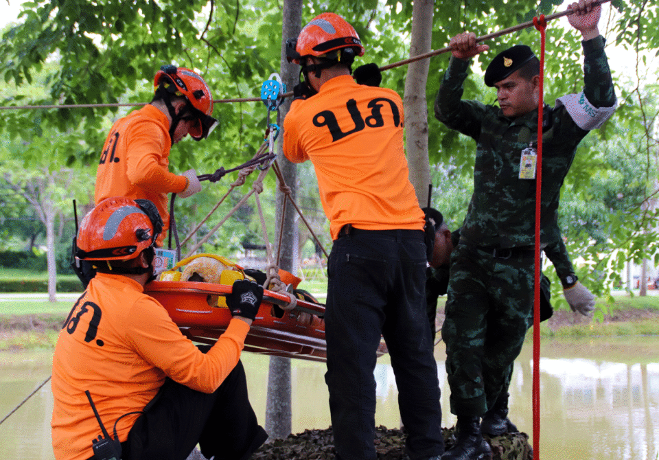 A team of rescuers moving a body on a stretcher