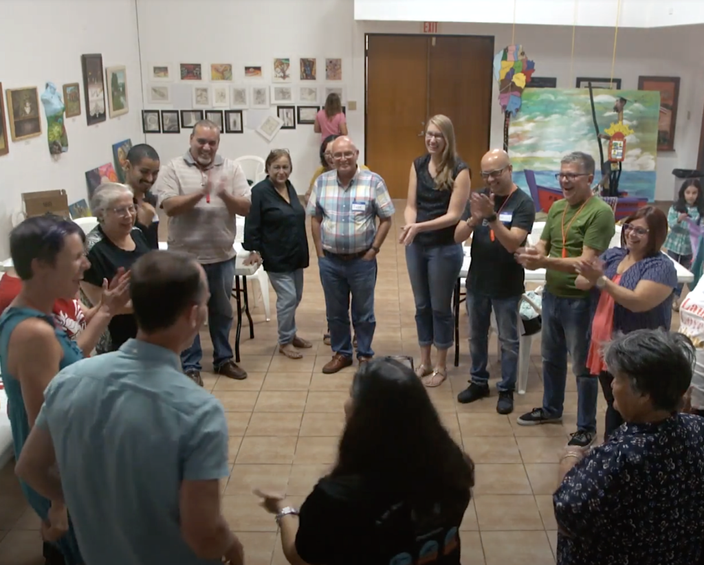 Group of people standing in a circle at a workshop 